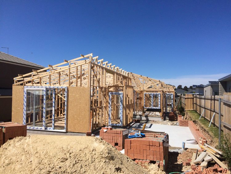 Single storey new build home under a clear blue sky